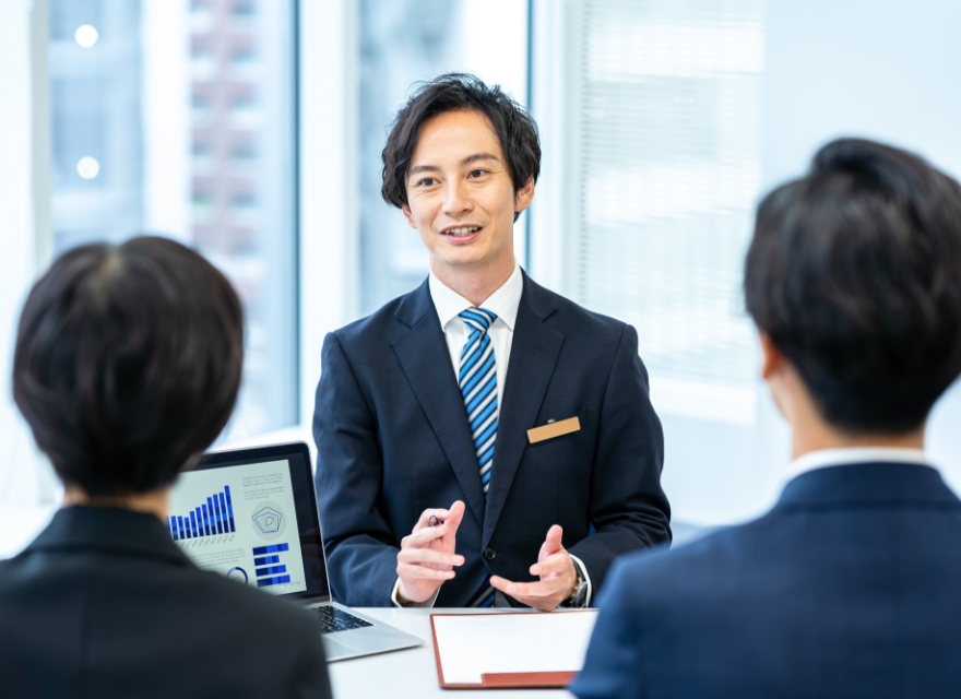 スーツを着用した男性が話している写真